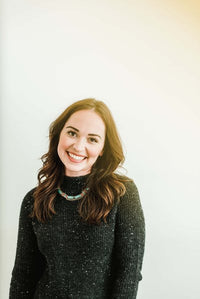 Shelbi McCarthy; woman smiling in a gray sweater