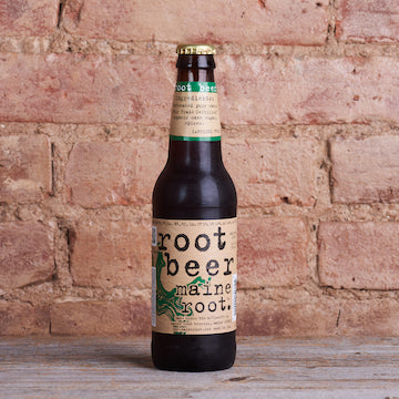 Maine Root Root Beer soda in a bottle in front of a brick wall