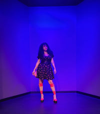 Estefany posing for a picture in front a blue background