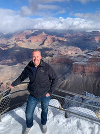 Chris posing for a picture in front of a mountain range