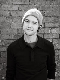 Mike Bruna posing for a photo in front of a brick wall