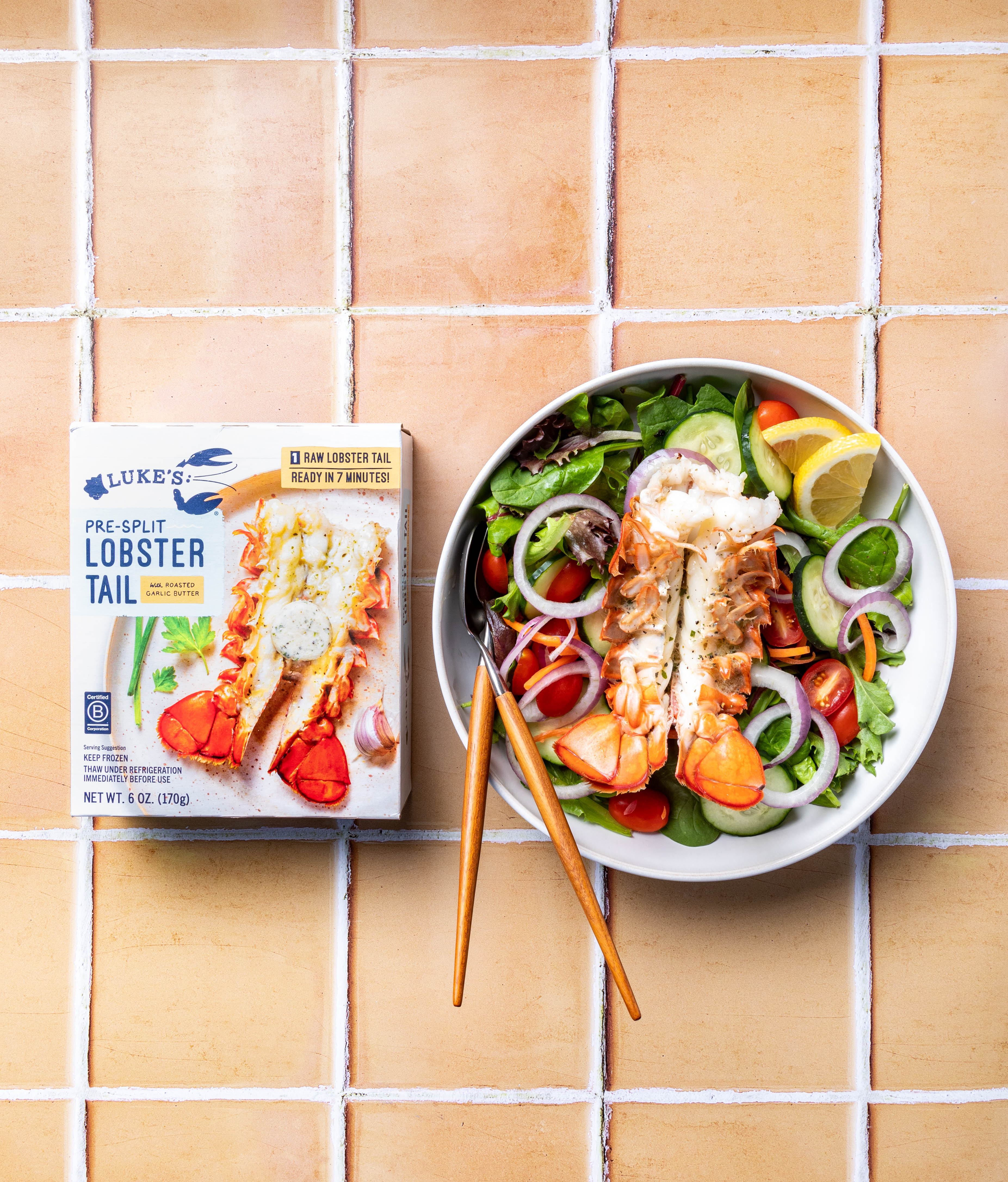 a photo of our lobster tail packaging beside a bowl of lobster tails on a salad