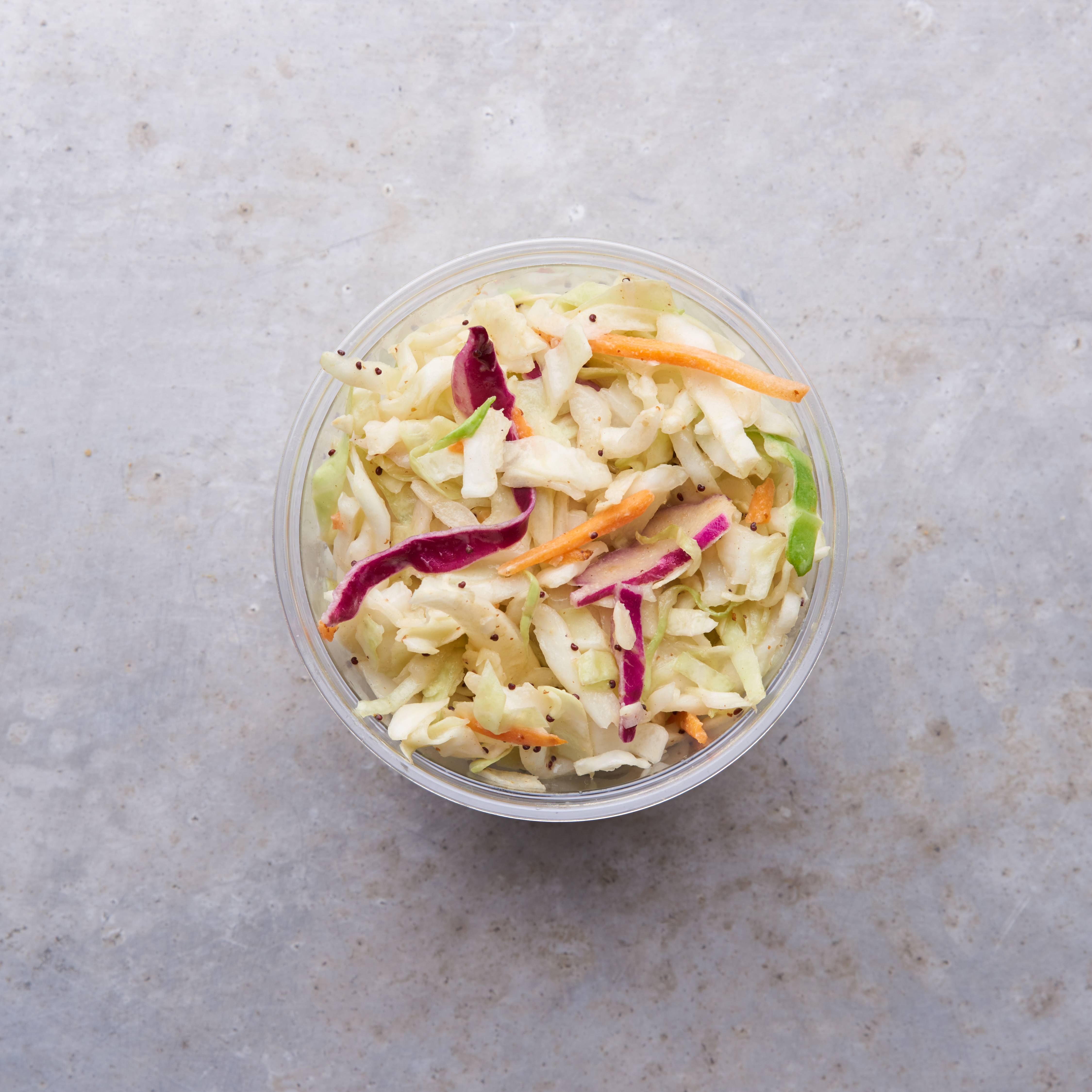Poppyseed coleslaw in a container on a metal table