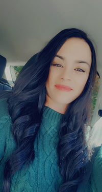 Meghan McMahon; a long brown haired woman with a green sweater