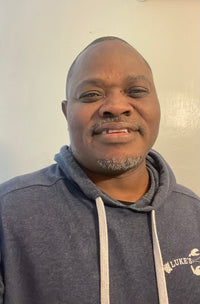 Jose smiling for a picture while wearing a navy Luke's sweatshirt