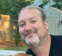 Colin leaning in for a picture wearing a black tshirt