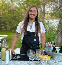 Matt Berry smiling for a picture while working as a bartender at an outdoor event