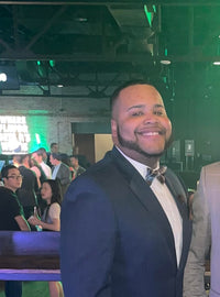 Daesan smiling while wearing a suit at an event