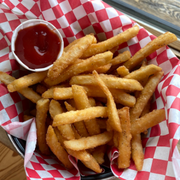 French fries in a basket lined with red and white wax paper