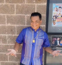 Johnny posing for a picture while wearing a purple button down shirt